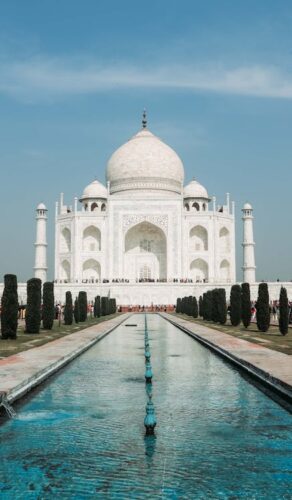 Taj Mahal sous un ciel bleu avec bassin et jardins, Agra, Inde