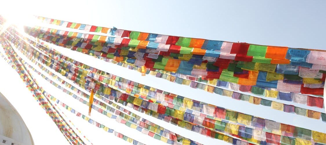 Drapeaux de prières bouddhistes colorés flottant autour d'un stupa, Népal