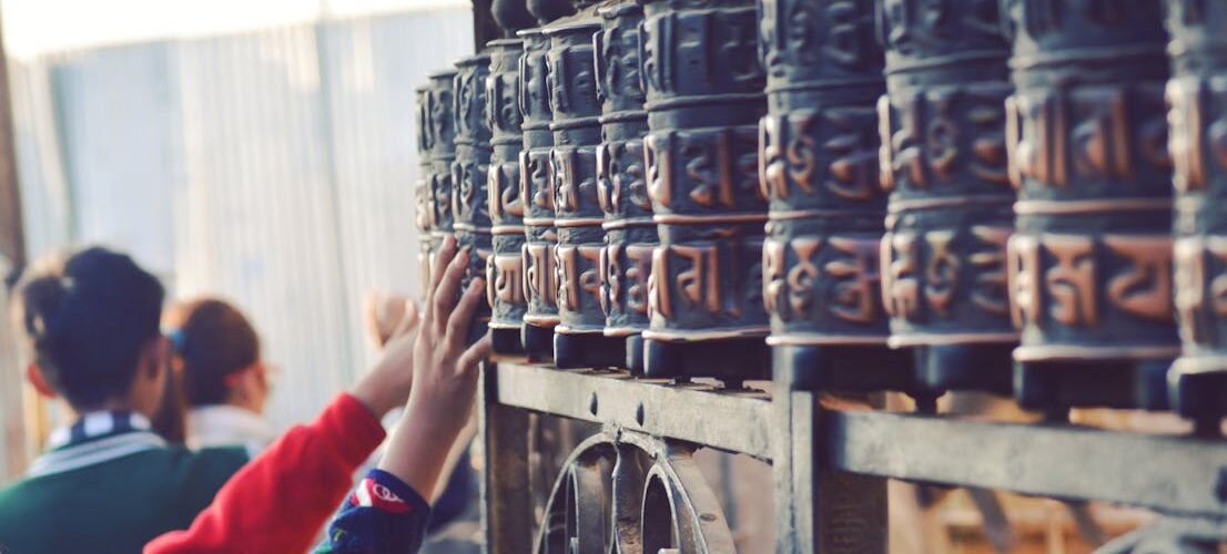 Pèlerins faisant tourner des moulins à prières bouddhistes dans un temple, Népal
