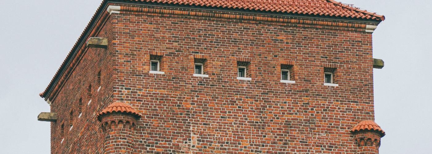 Tour en briques rouges du château de Wawel à Cracovie avec drapeau polonais
