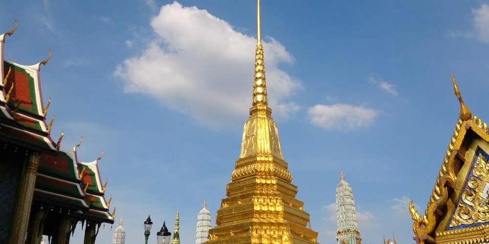 Temple du Bouddha d'Émeraude avec stupa doré sous un ciel bleu, Bangkok, Thaïlande