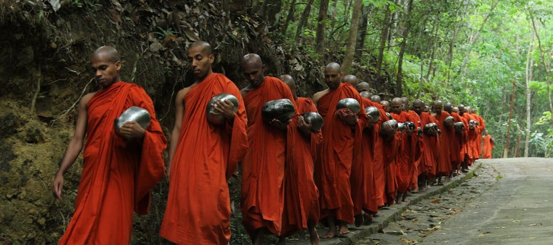 Moines bouddhistes en robe safran marchant en file indienne, Thaïlande