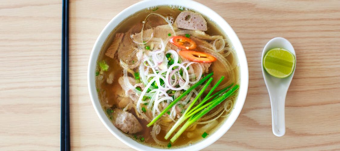 Bol de phở vietnamien garni d'herbes fraîches et d'épices