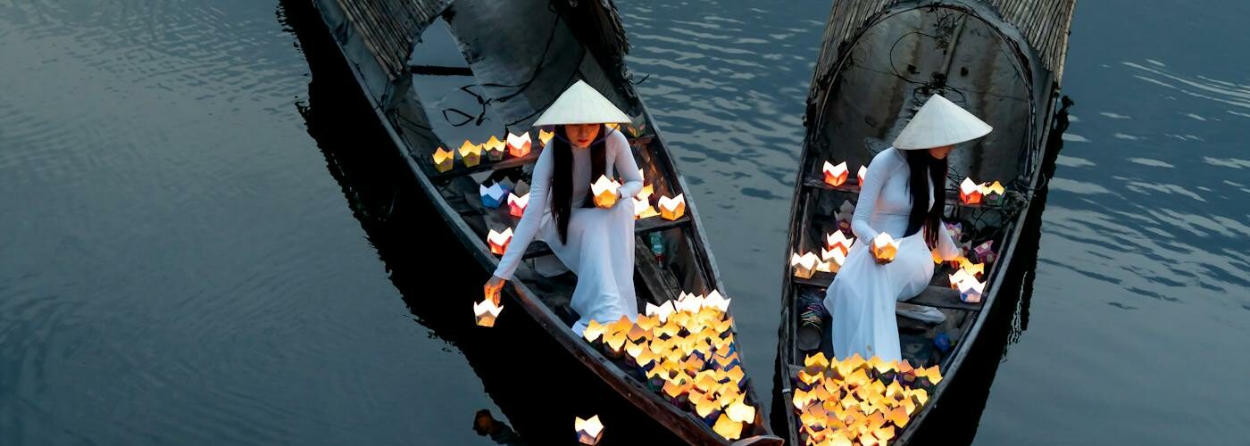 Bateaux traditionnels et lanternes flottantes sur une rivière au Vietnam