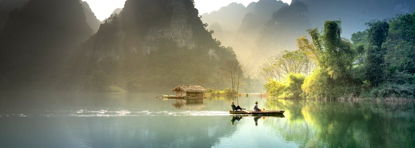 Barque sur une rivière brumeuse entre les montagnes karstiques du Vietnam