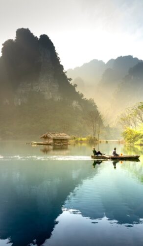 Barque sur une rivière brumeuse entre les montagnes karstiques du Vietnam